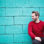 Happy man in front of wall